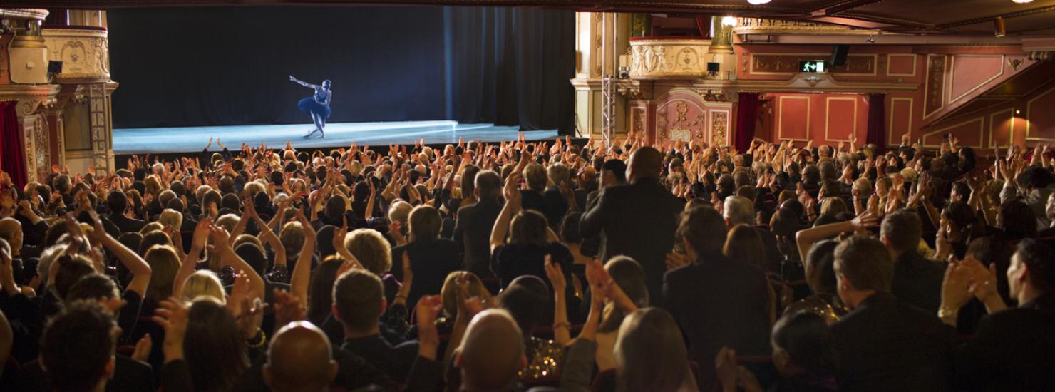 Ballerine sur scène de théâtre et public qui applaudit